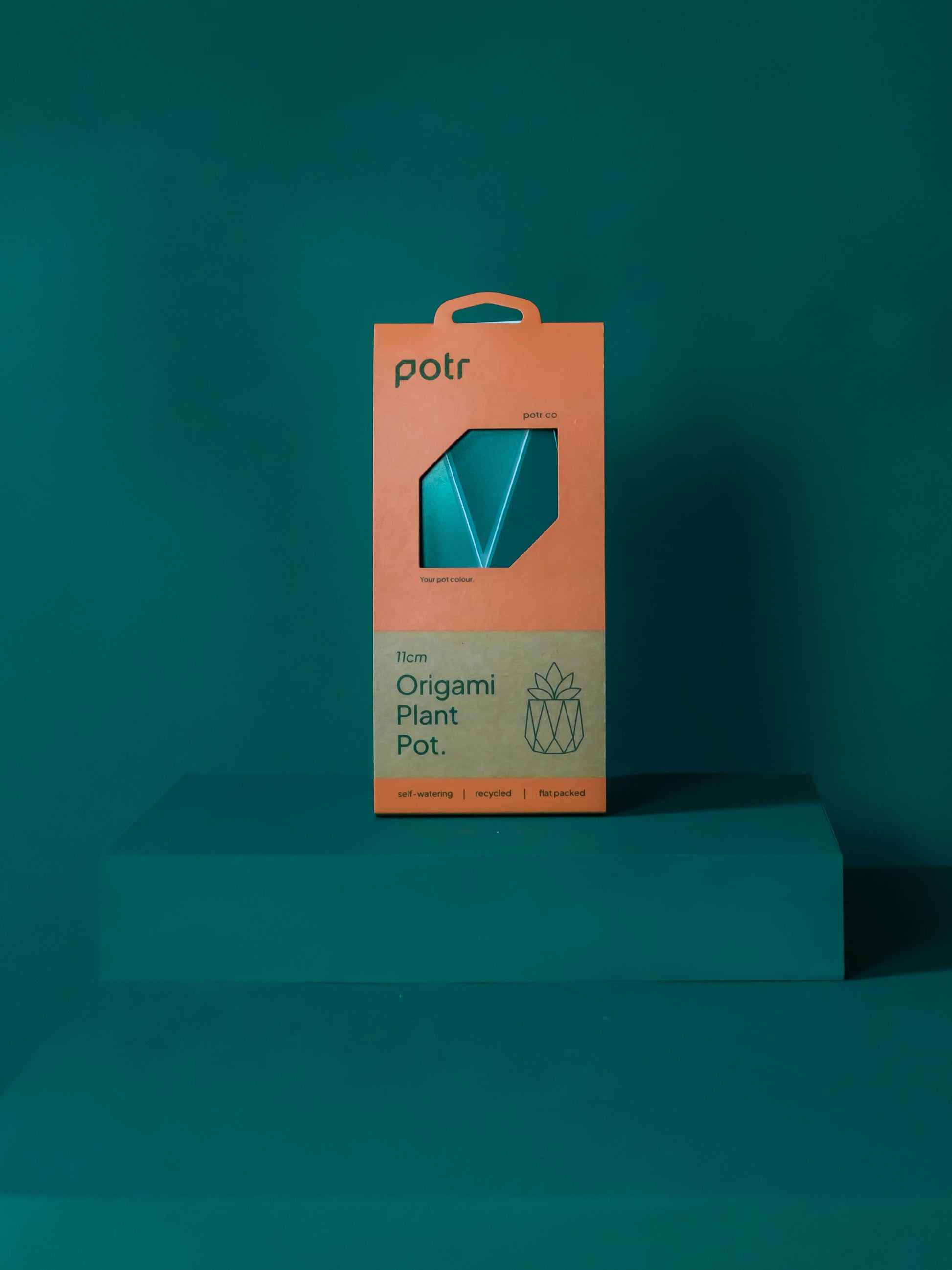 Churchill & Green origami style self-watering plant pot in teal blue packaging on green background